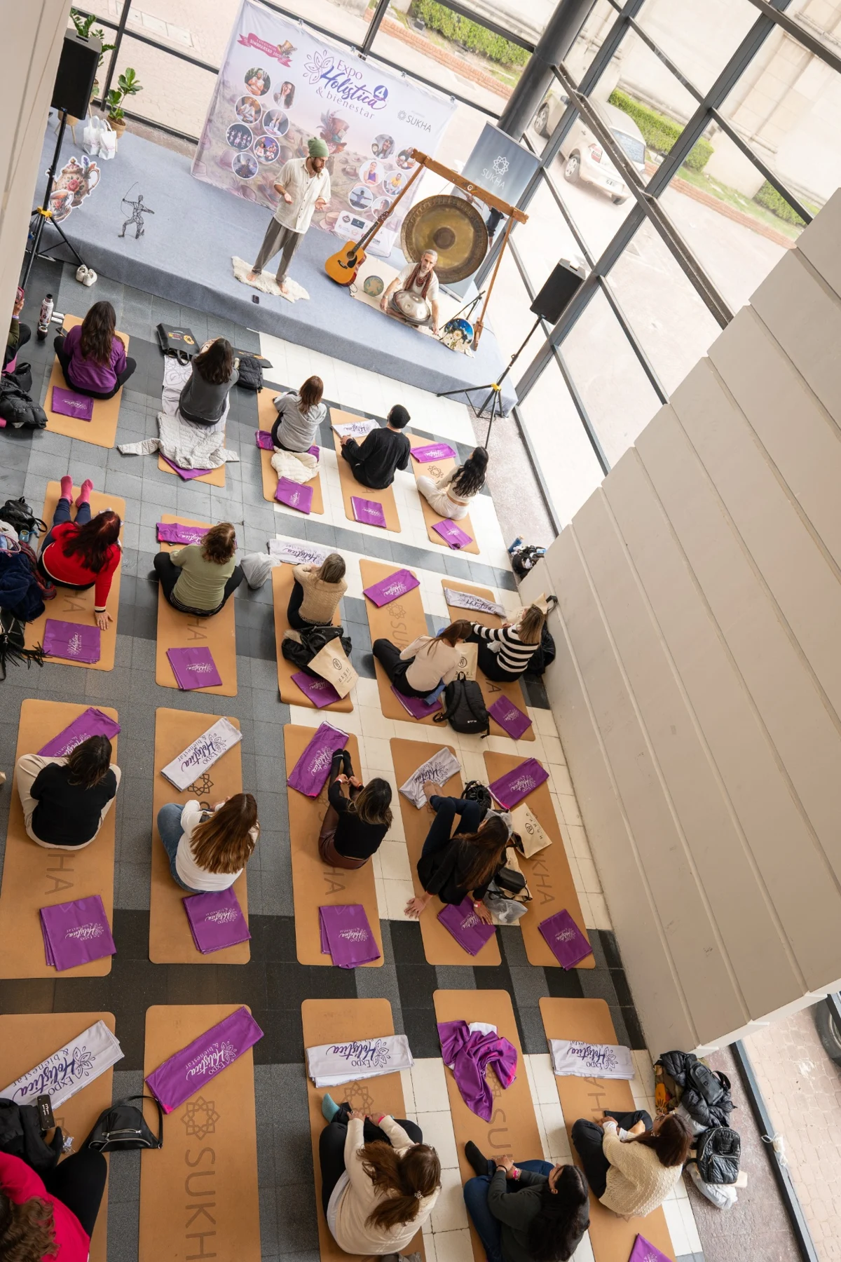 Encuentro de Yoga y GONG con facilitadores y un grupo de participantes en un salón luminoso